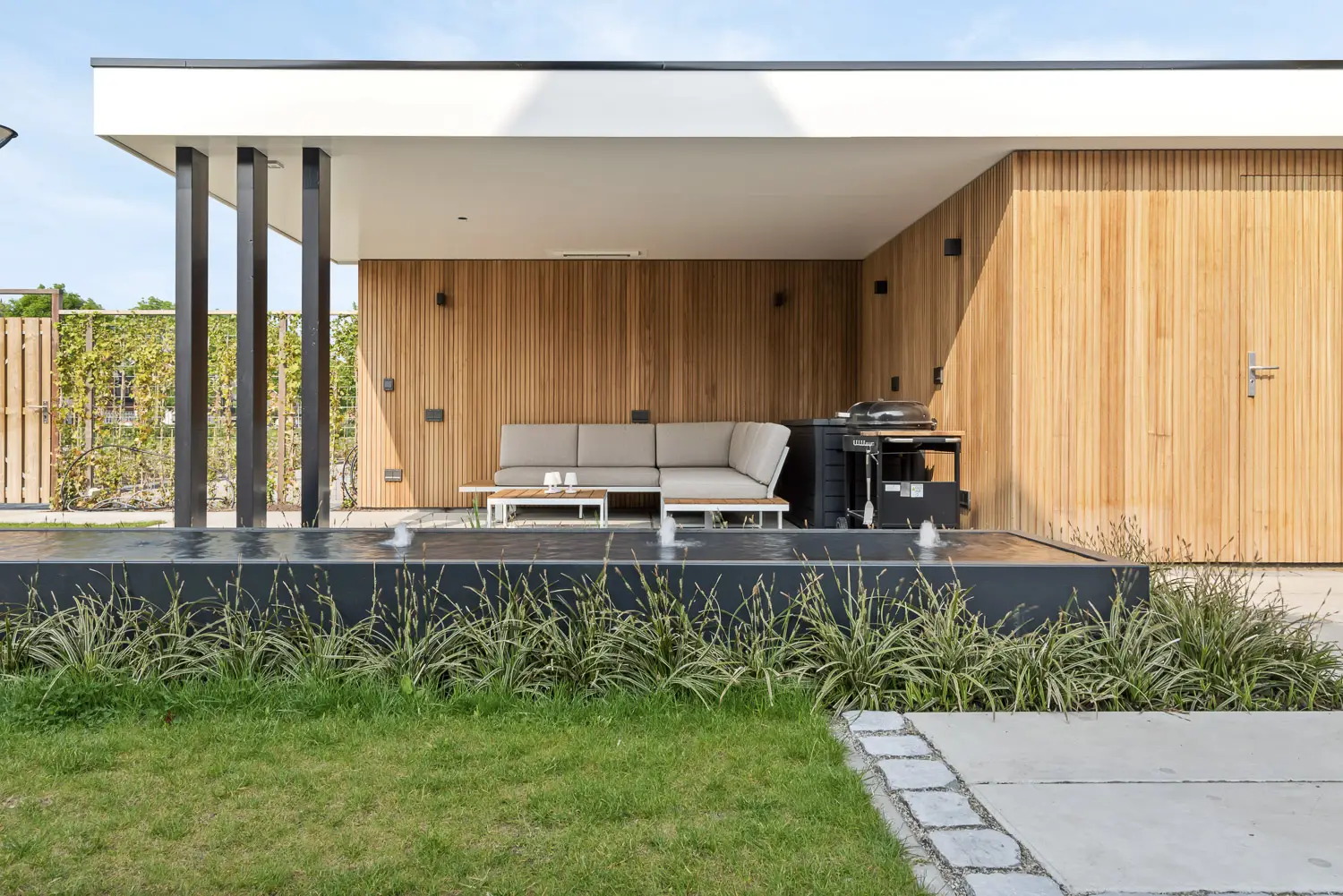Tuin met overkapping en vijver