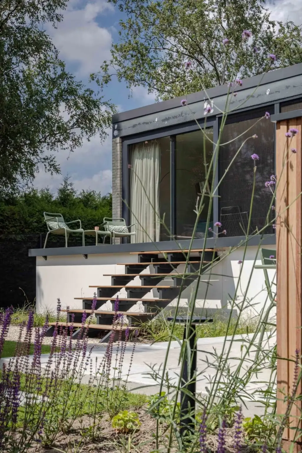 Ruime tuin met hoogteverschil en maatwerk overkapping